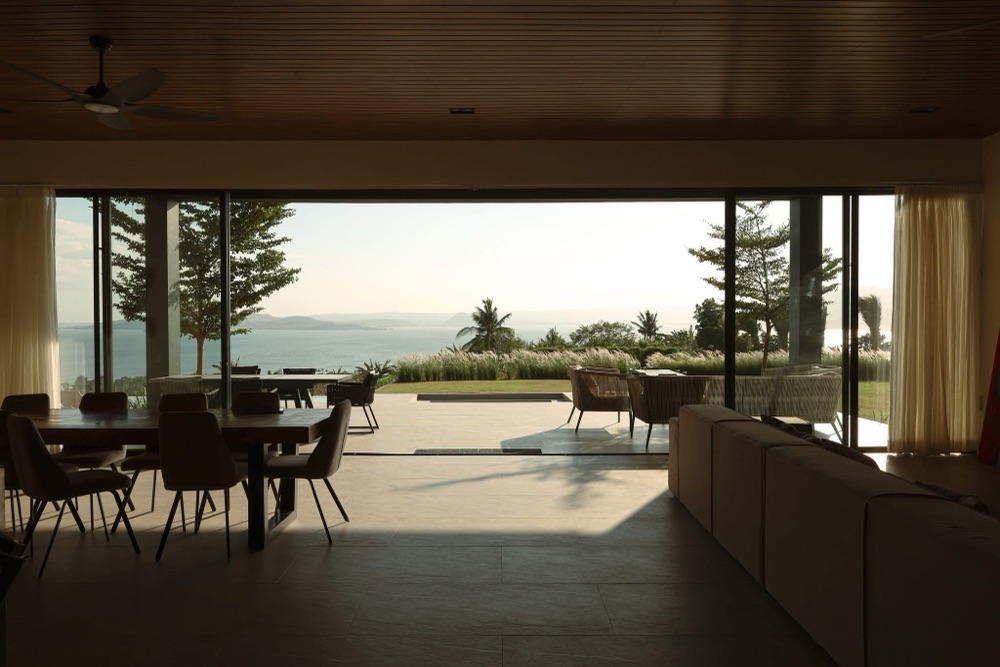Balai Eremaya — living and dining opening onto a covered terrace above the water.