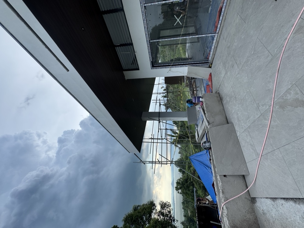 Balai Fariñas 2 under construction — the terrace under a deep dark soffit, looking west over Taal.
