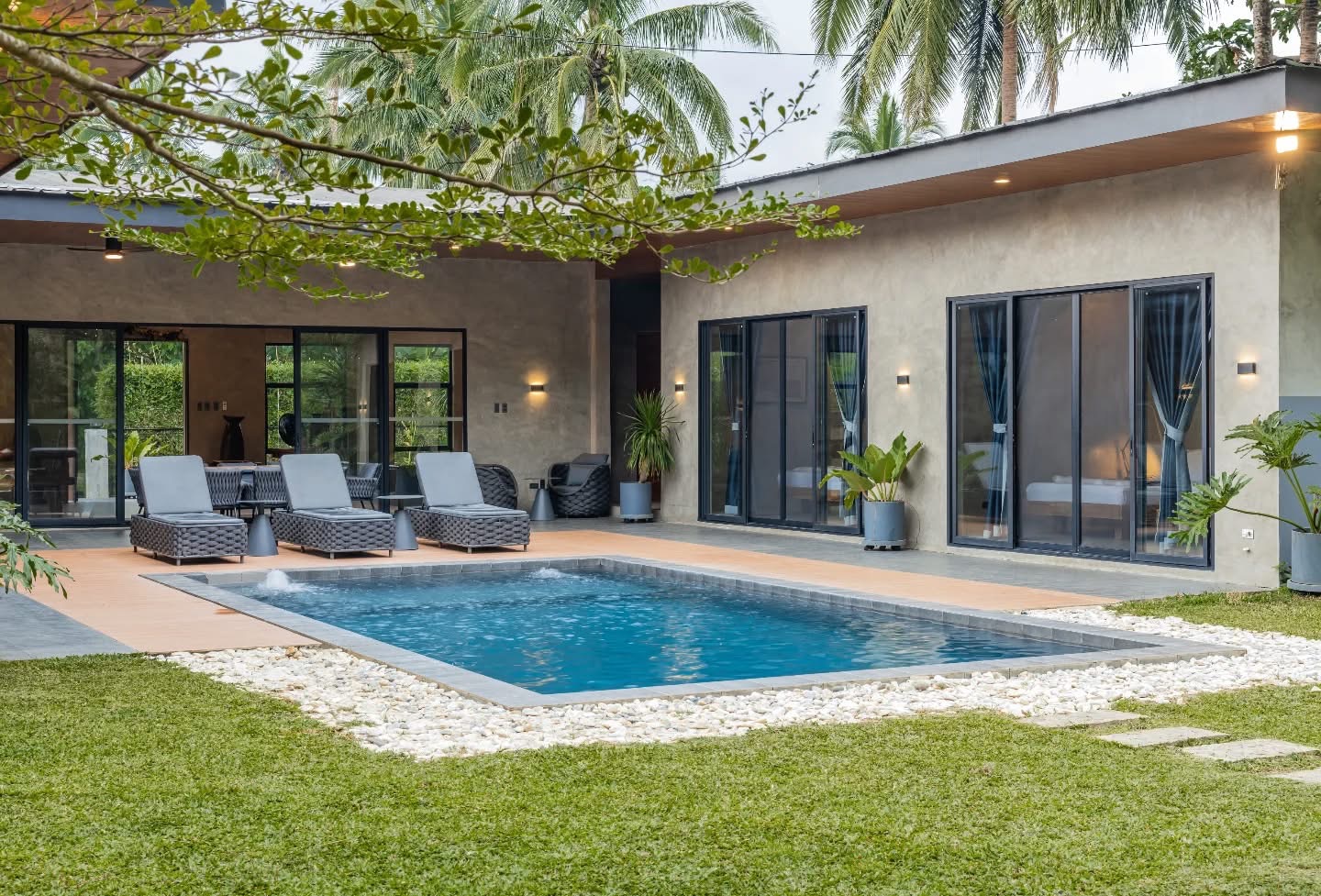 Casa Fariñas — pavilions in textured concrete set around a pool, under coconut palms.