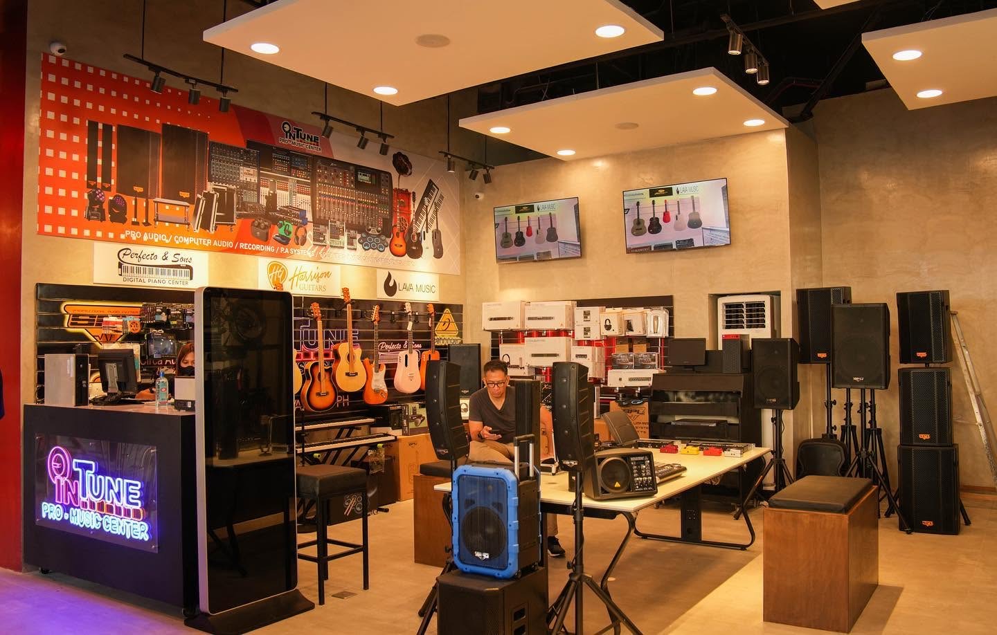 Elektric Avenue — music and audio retail floor with wall-hung guitars and stacked PA.